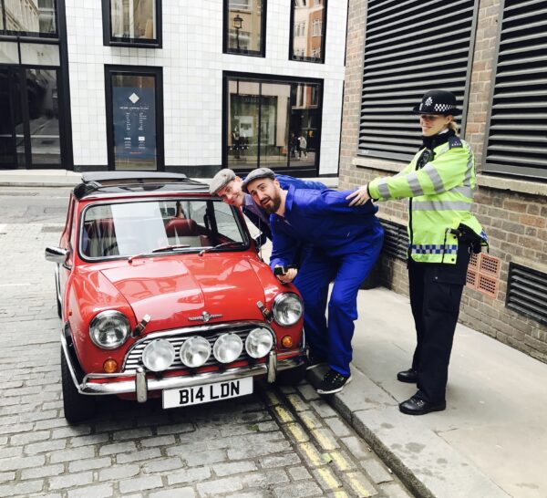 smallcarBIGCITY-Classic-Mini-Cooper-hire-Car-tours-of-London-Stag-Hen-ideas-Red-Mini-jumpsuits-woman-police-officer-being-arrested